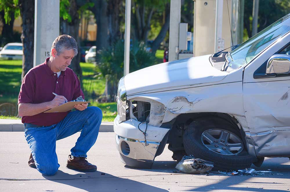 Insurance Adjuster Analyzing Damaged Car on the Road - BidGoDrive Insurance Services